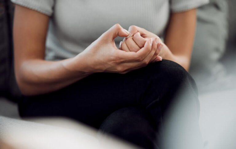 Patient's hands clasped in anxiety therapy session
