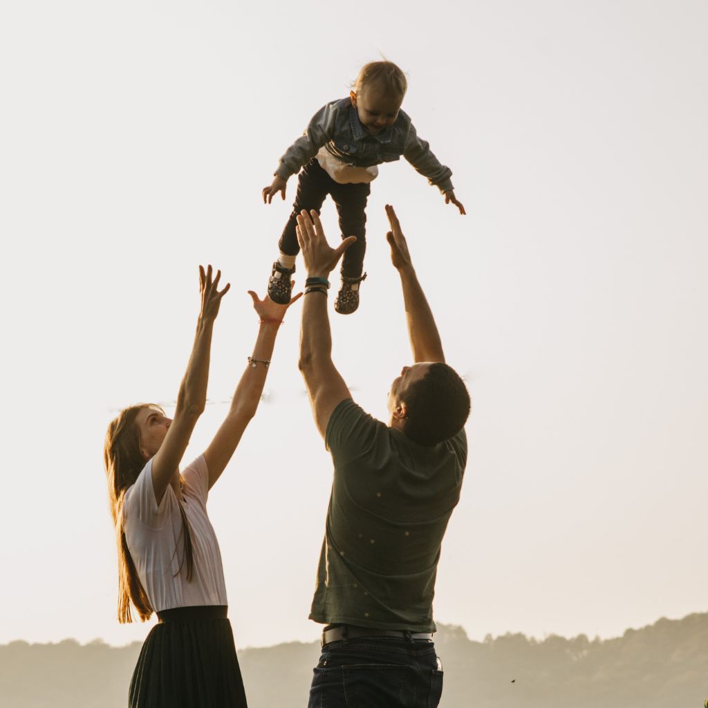 Parents playfully lifting their child, a moment of joy and unity after therapy.