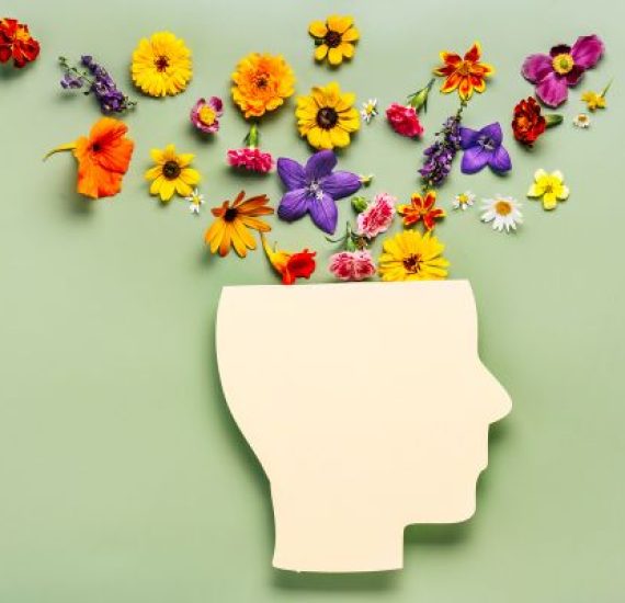Bright flowers spreading from head cutout, depicting mental well-being.