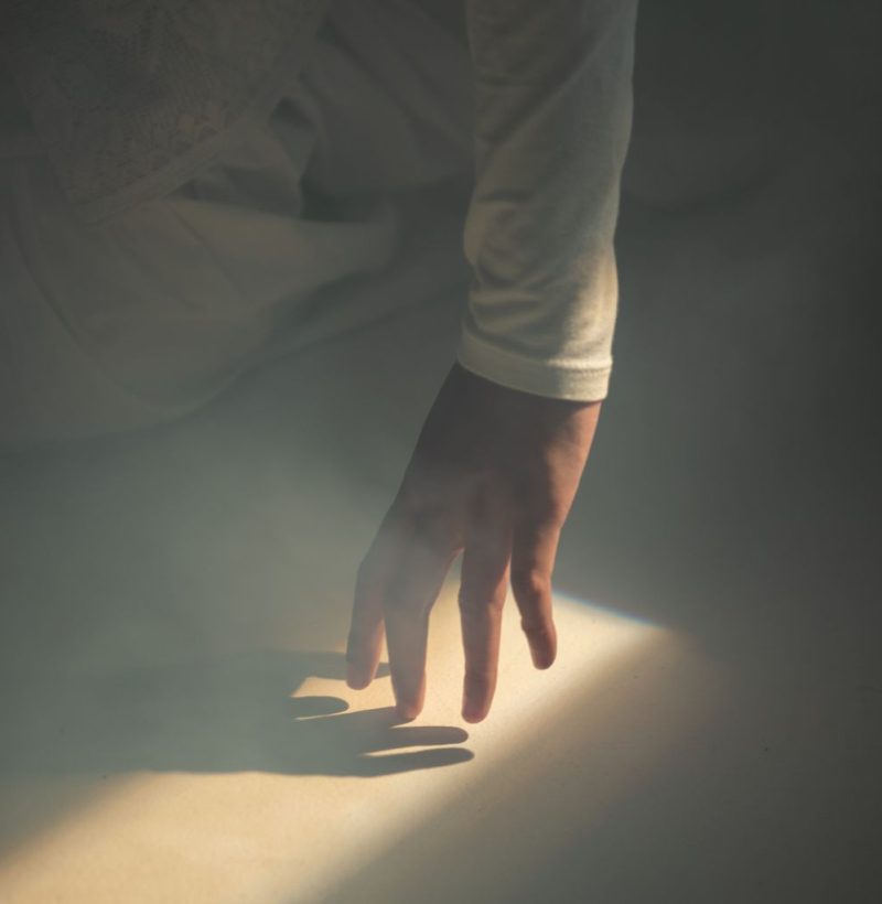 Hand reaching towards light, symbolizing progress in trauma-focused therapy.