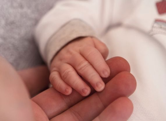Newborn's hand in mother's grasp, illustrating trust and the beginning of a lifelong bond.