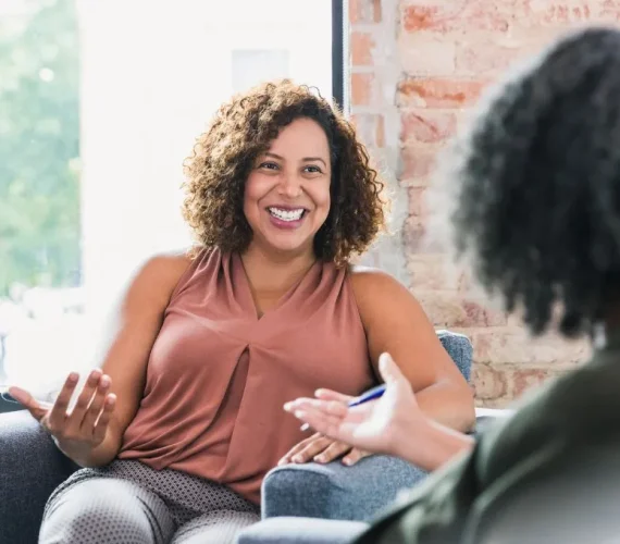 A woman smiling, actively engaging in a productive individual therapy session.